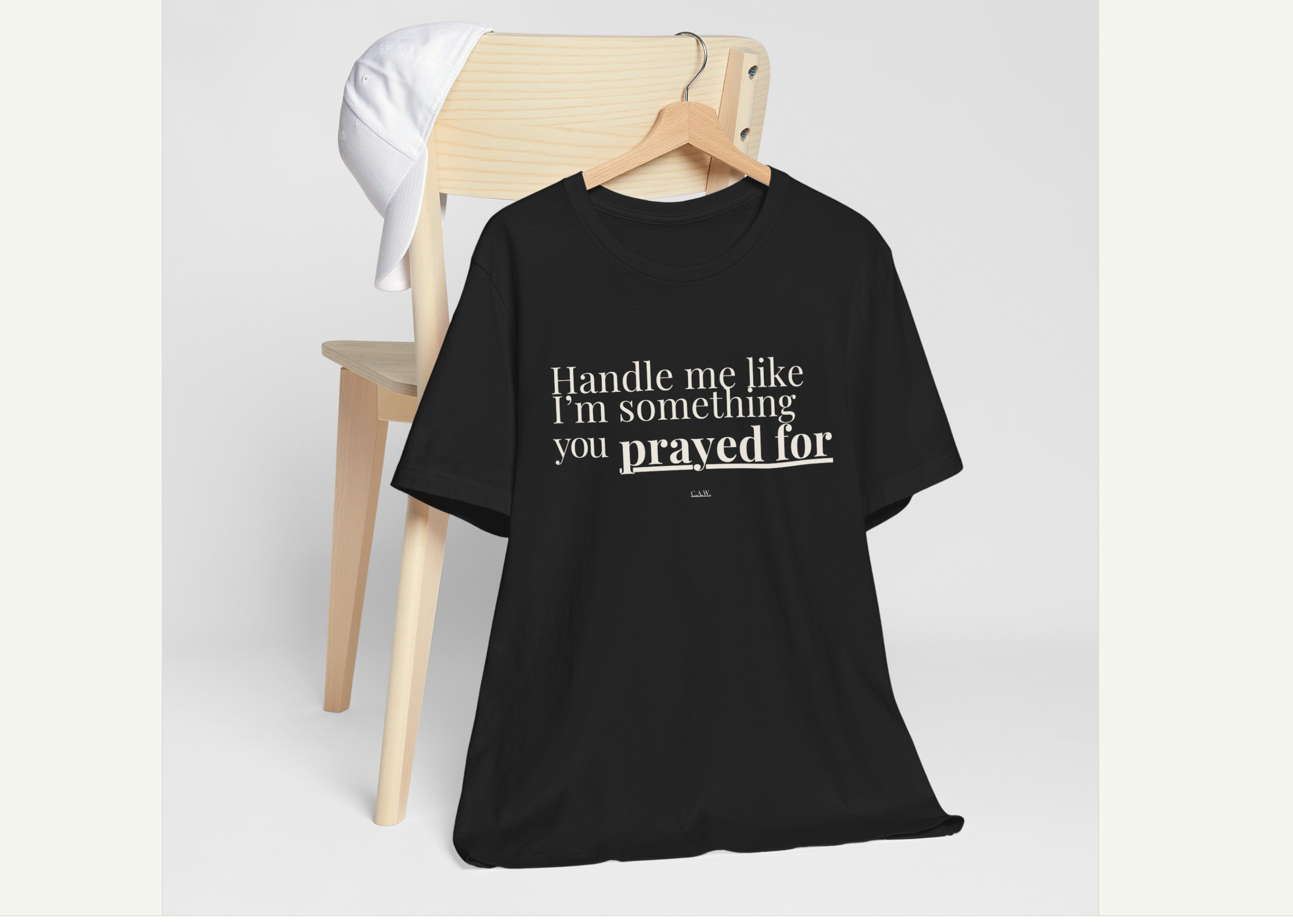 Black t-shirt with text on a hanger against a white background, displayed on a website.
