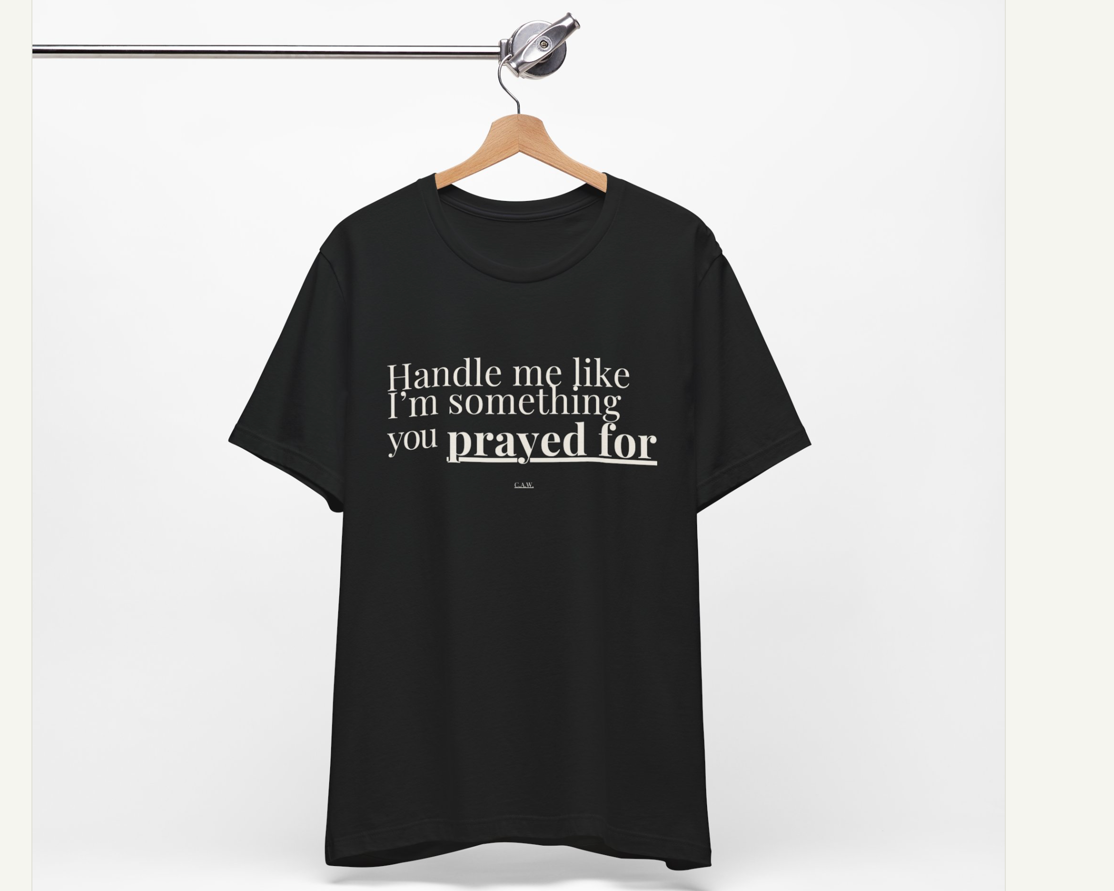 Black t-shirt with text on a hanger against a white background